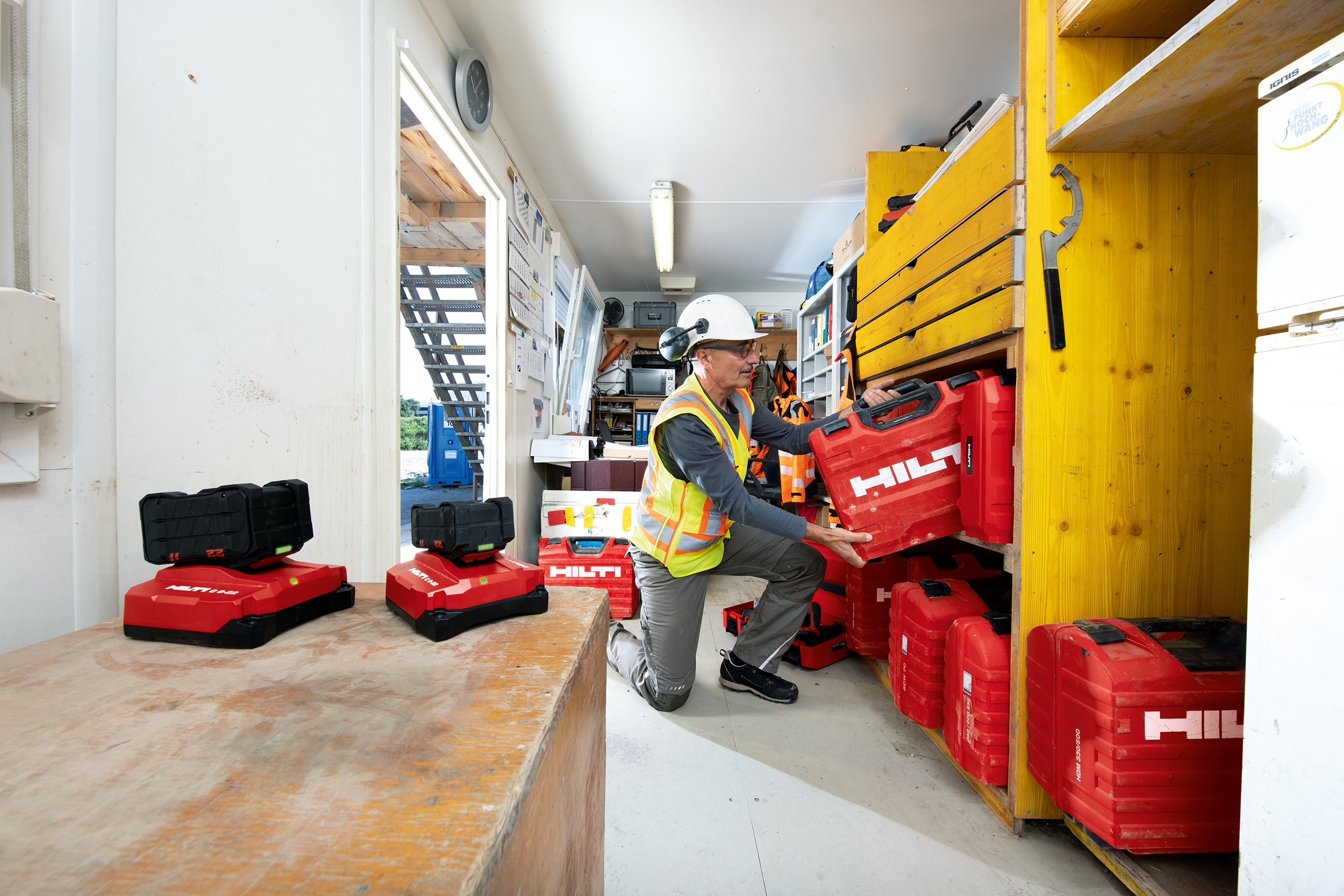 Tool Crib Manager putting away a Hilti Tool Box on a shelf in a construction container